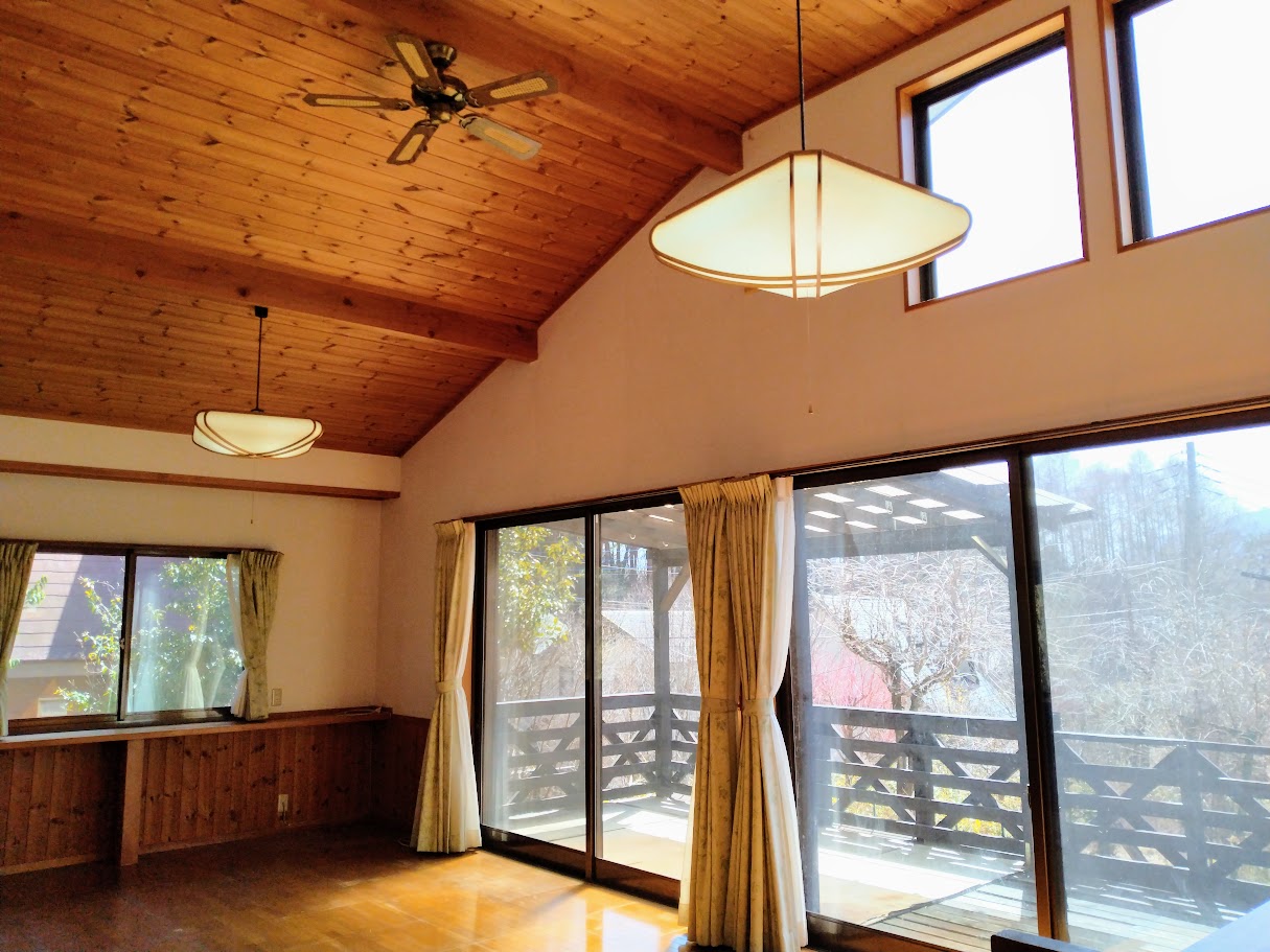 高さのある勾配天井、窓が大きく開放的な空間。