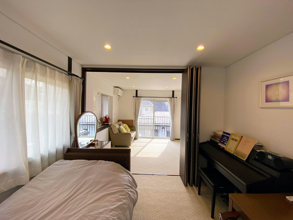 2階洋室（約12帖）。仕切りで2部屋になる。