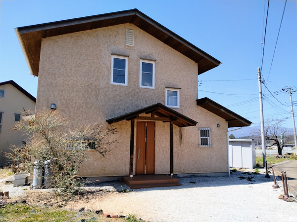 温かみある外壁、日当たりのいい二階建て住宅。
